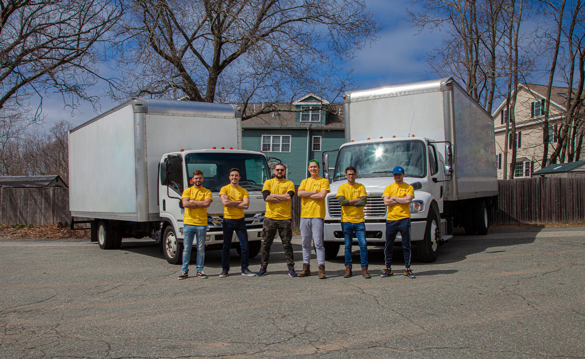 Milvus team photographed beside two moving trucks